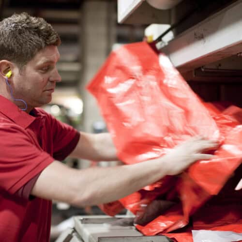 Operative throwing polythene waste into baler