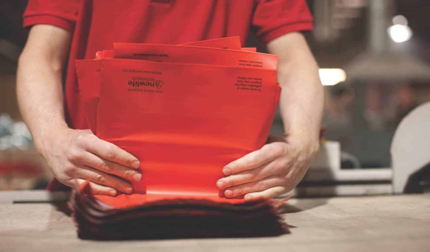 Operative folding a pile of mailing bags