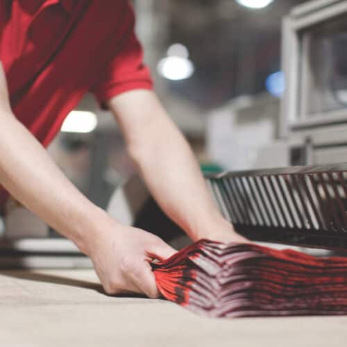 Operative holding mailing bags coming off a machine