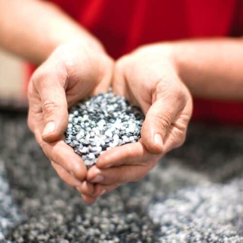 Persons hands cupped with recycled polyethene pellets