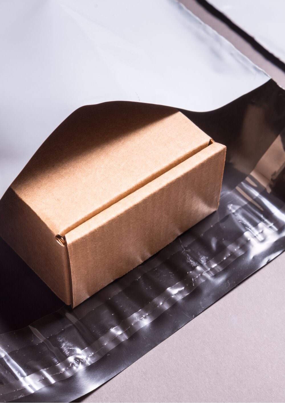 Cardboard box in a white mailing bag