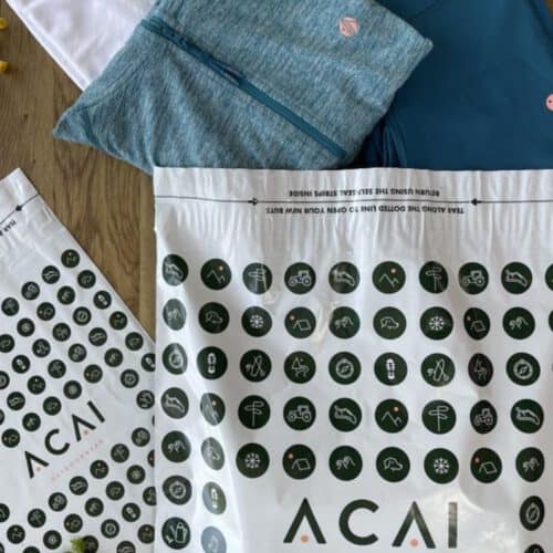 ACAI Outdoorwear Branded mailing bags manufactured by Duo UK with ACAI's products positioned coming out of the branded mailing bag.