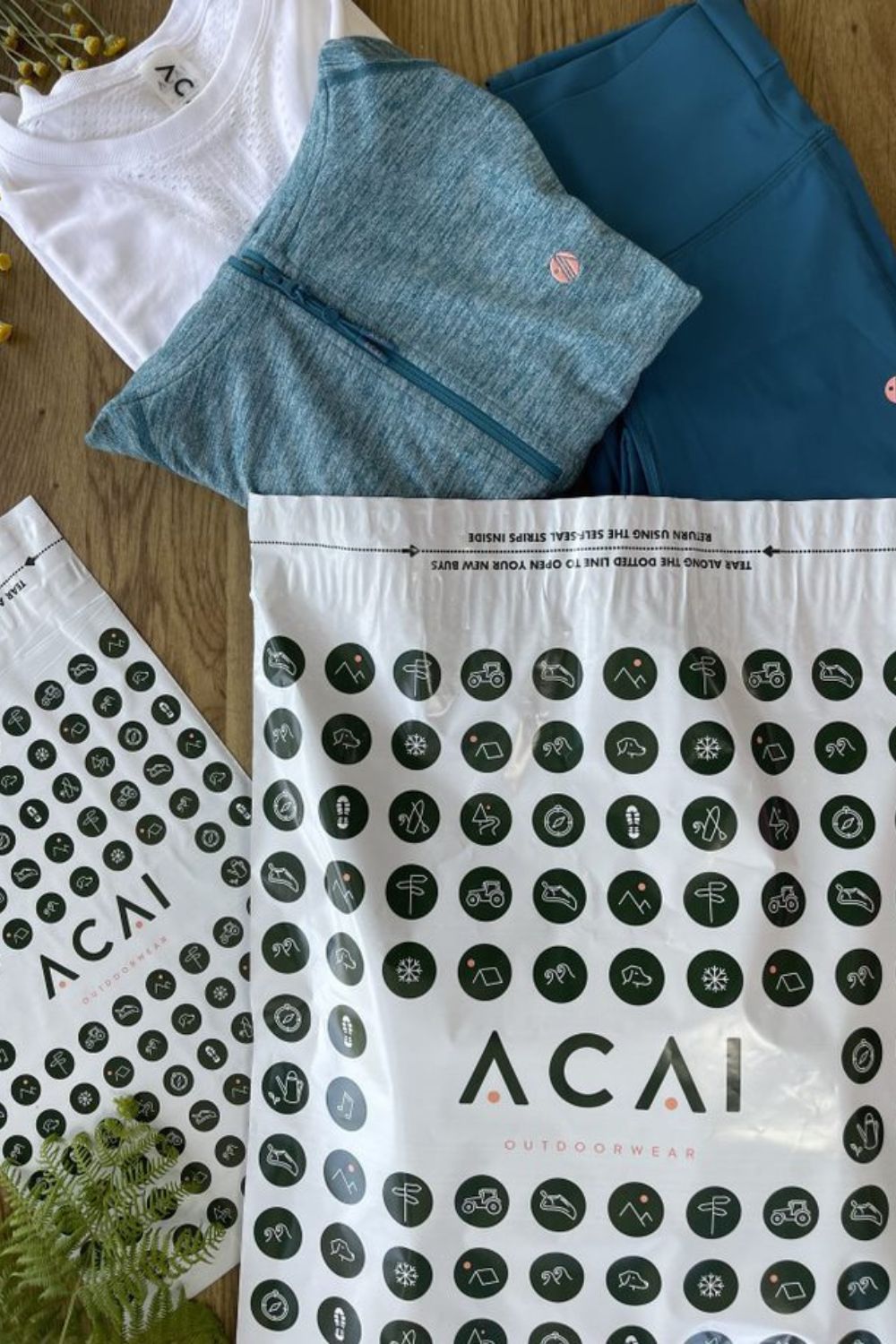 ACAI Outdoorwear Branded mailing bags manufactured by Duo UK with ACAI's products positioned coming out of the branded mailing bag.